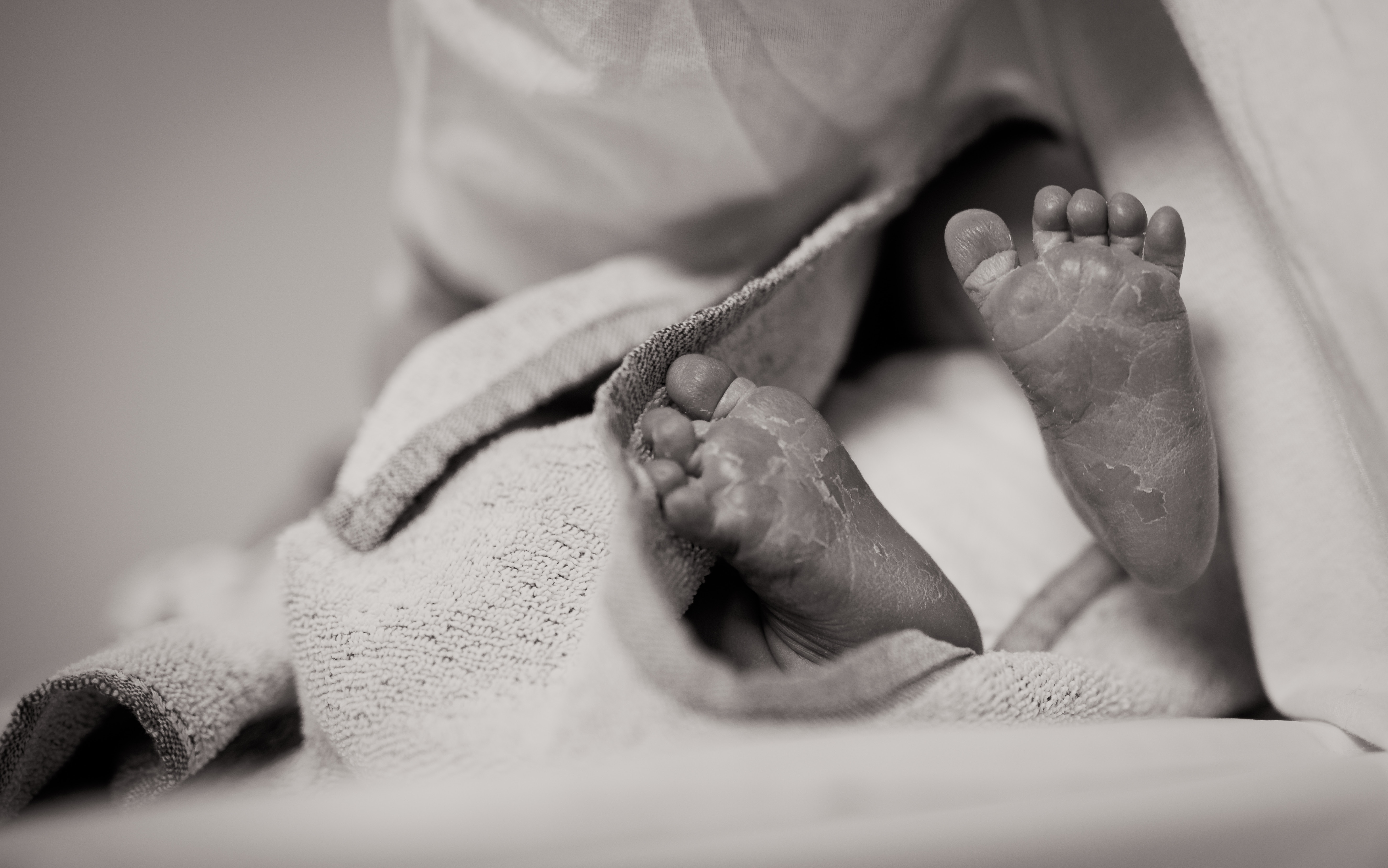 black and white photo of the feet of a newborn