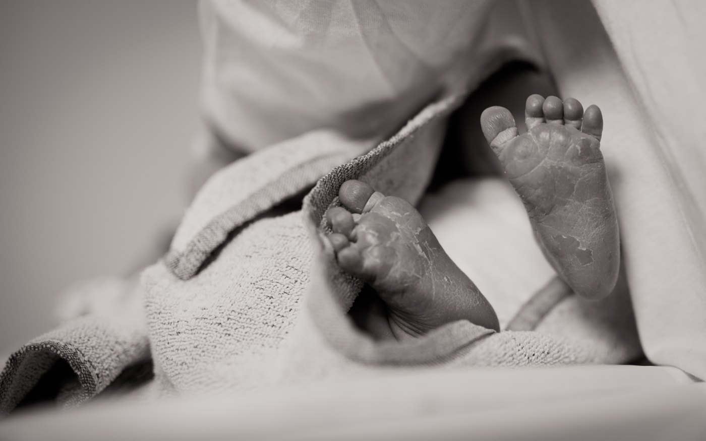 black and white photo of the feet of a newborn